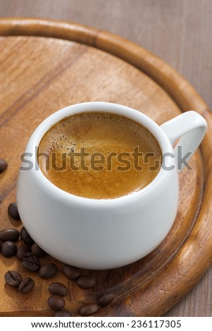 cup of coffee on a wooden tray, vertical, close-up