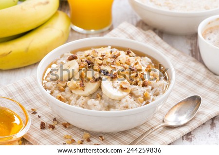 oatmeal with banana, honey and walnuts for breakfast, close-up