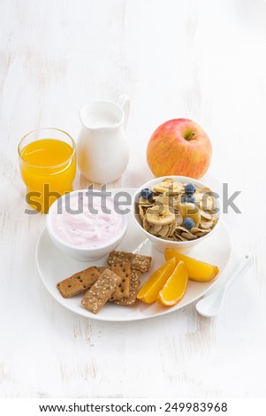 healthy breakfast - cereal, fruit, yogurt and juice, vertical, top view