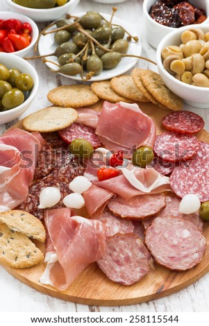 Assorted meat snacks, sausages and pickles, top view, close-up, vertical