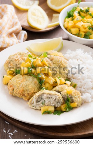 fish cakes with mango salsa and rice, vertical, close-up
