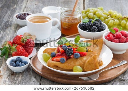 breakfast - crepes with fresh berries and honey, coffee, horizontal