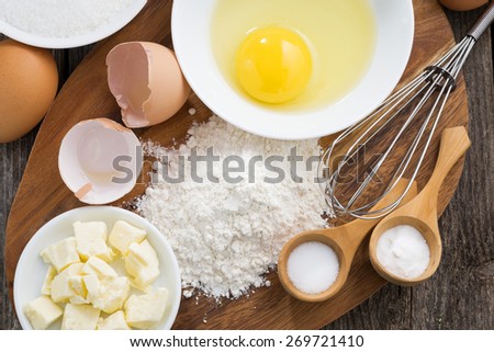 prepared fresh baking ingredients on a wooden board, horizontal, top view, close-up