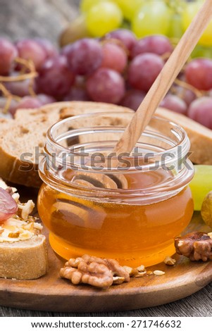 flavored honey, bread with butter and grapes, vertical photo, close-up