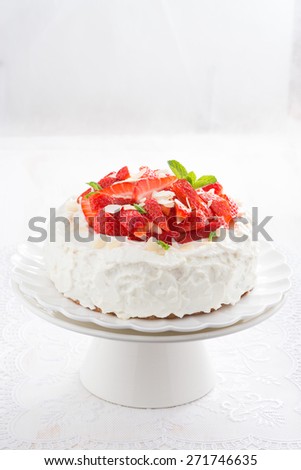 cake with whipped cream and strawberries on a stand, vertical, close-up