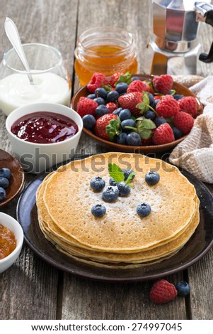 crepes, fresh berries and jams, vertical, close-up