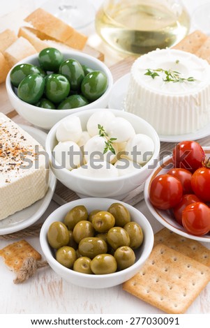 Assorted soft cheeses and pickles on table, vertical, top view
