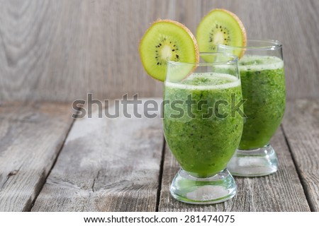 fruit and vegetable green smoothie on a wooden table, close-up