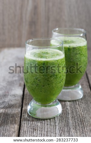 Green fruit and vegetable smoothies, vertical, close-up