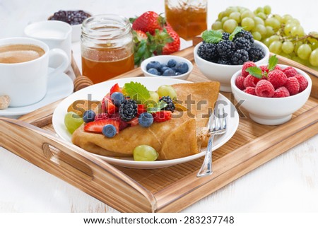 delicious breakfast - crepes with fresh berries and honey, horizontal