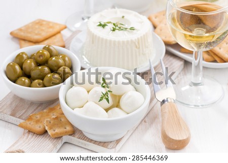 fresh soft cheeses, crackers and pickles to wine, close-up, horizontal
