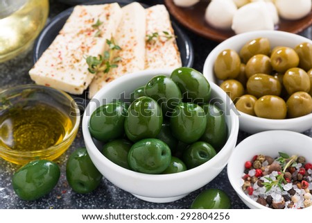 snacks - green olives and soft cheeses, close-up, horizontal