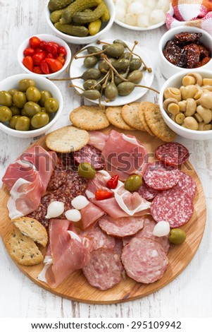 Assorted meat snacks, sausages and pickles, top view, vertical