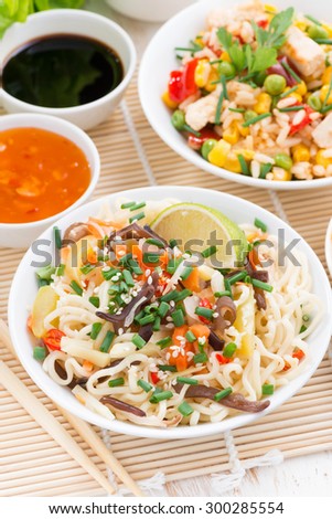 Asian food - noodles with vegetables and greens, fried rice with tofu, vertical, top view