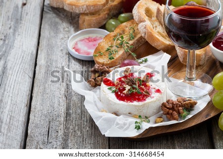 delicious appetizers - camembert with berry jam, toast and grapes, close-up