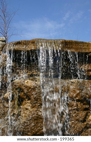The top of a waterfall created in this garden by some good landscape contractors