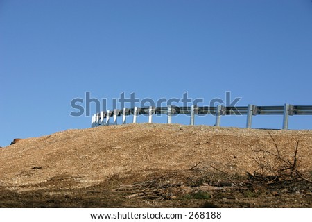 A roadside crash barrier against a blue sky
