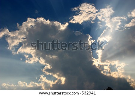 The sun\'s rays escaping from behind a large cloud