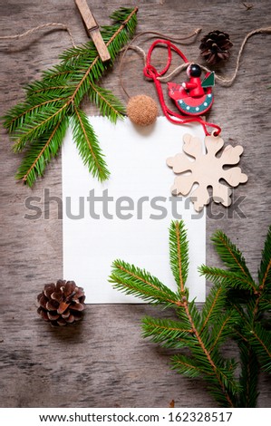 Christmas fir tree with paper and  decoration on a wooden board