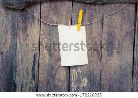 photo paper attach to rope with clothes pins on a wooden background