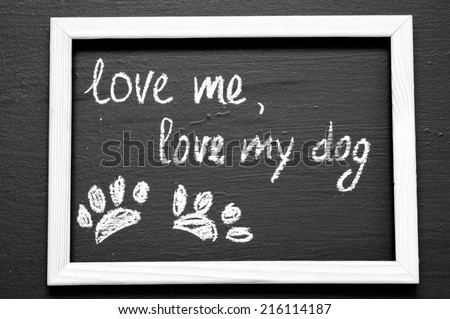 Love me, love my dog written with Chalk on Blackboard