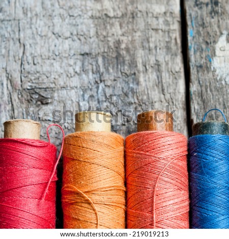 Vintage Background with colorful bobbins with thread  on the old wooden background