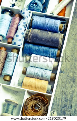 Vintage Background with sewing/Sewing kit.Bobbins with thread and needles with retro filter