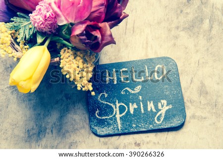 Hello spring. Spring flowers on a wooden background. Toned photo