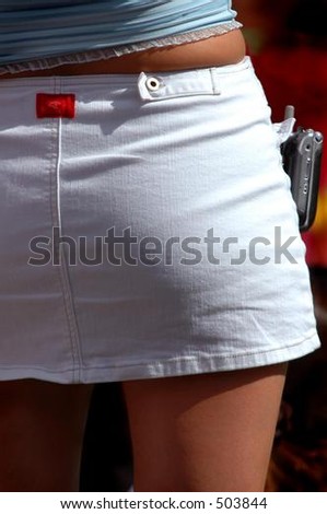 Woman in white mini skirt with cell phone clipped to side