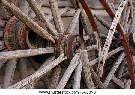 Broken wagon wheels leaning against wall