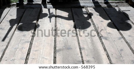Shadow / Silhouette of three gunfighters on barn board flooring