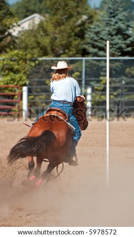 Turn around the Pole - cowgirl and her horse make turn around pole during pole weaving competition