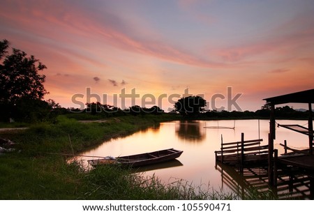 Swamp sunset with boat and house