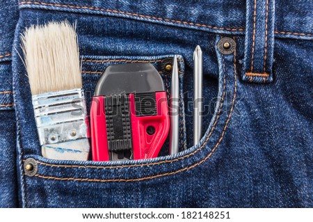 brush, cutter & screwdriver in blue jean pocket