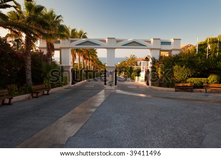 Territory of hotel with a path, palm trees and country houses