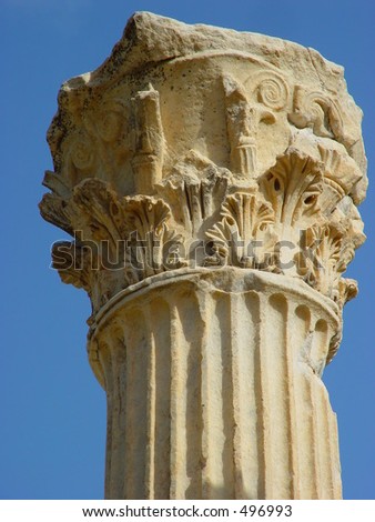 Top of roman pillar against clear blue sky