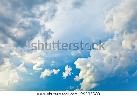 white and dark cumulus clouds against a bright blue sky without the sun