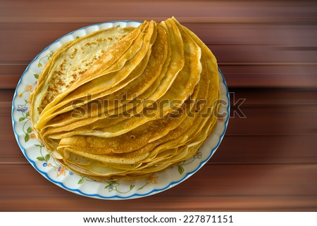 the plate of pancakes on the wooden table. top view