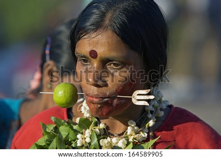 Kuala Lumpur, Malaysia, January 27 2013: A Hindu devotee with skewer protruding through her cheek during Thaipusam festival to fulfill their vows and offer thanks to the deities.