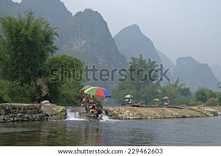 Guilin, China - 14 October 2014 - Tourists ride on a bamboo raft along the Yulong river, in Guilin China. Yangshuo County, in the northeast of Guangxi, China is one of the tourist spots in Guilin.