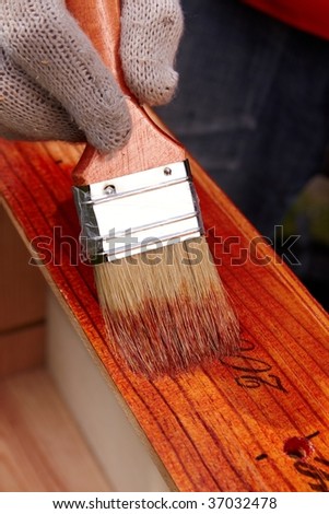 Protective lacquer coating wood surfaces with a construction brush. Do it yourself. DIY