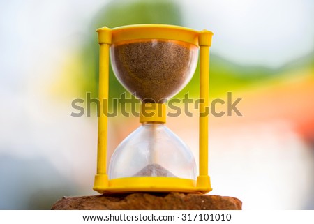 sand clock placed on a brick and shot outdoors in daylight with a macro lens