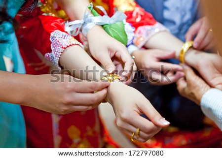 Elderly relatives presenting the golden bracelet as a blessing in chinese wedding