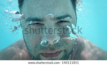 Underwater portrait of man with bubbles in a sea