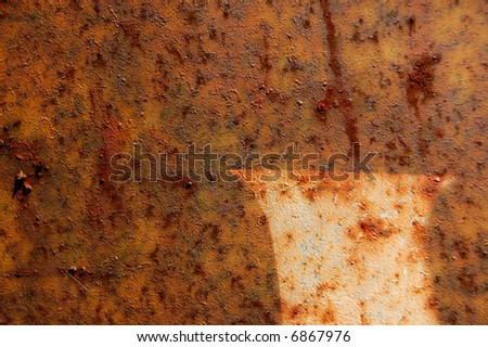 Type stencil detail on rusted metal surface. Abstract background texture.