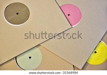 Cardboard sleeve vinyl music records with colorful blank labels.