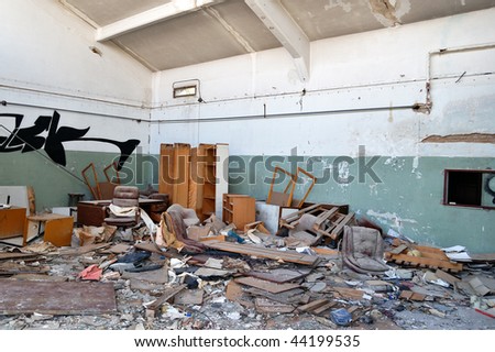 Vandalized office equipment and debris in a partially demolished abandoned factory.