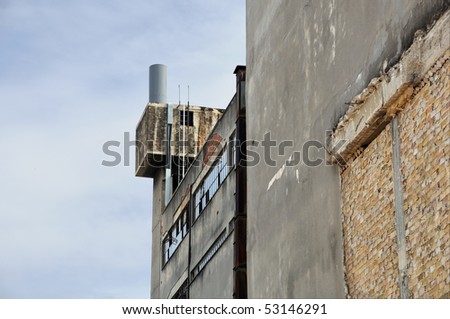 Abandoned factory exterior and crumbling wall. Industrial building.