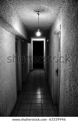 Dim light glowing in dark underground corridor.