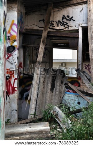 Broken cement asbestos roofing in derelict house. Hazardous waste in urban area.